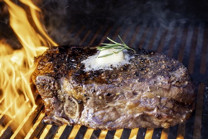 Seared Tomahawk Steak with Rosemary and Butter on Open Flame Grill